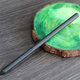 A photo of the S Pen standalone stylus laid across a green marbly coaster